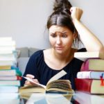 Women frazzled by a pile of books