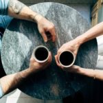 Two people holding coffee cups